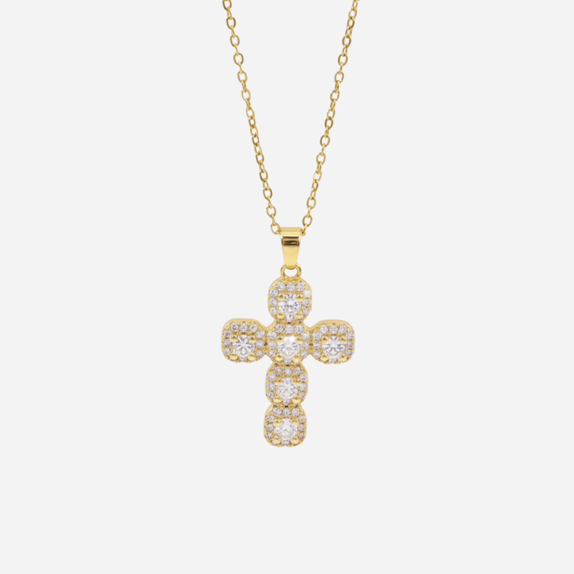 Gold cross necklace with diamonds on a white background