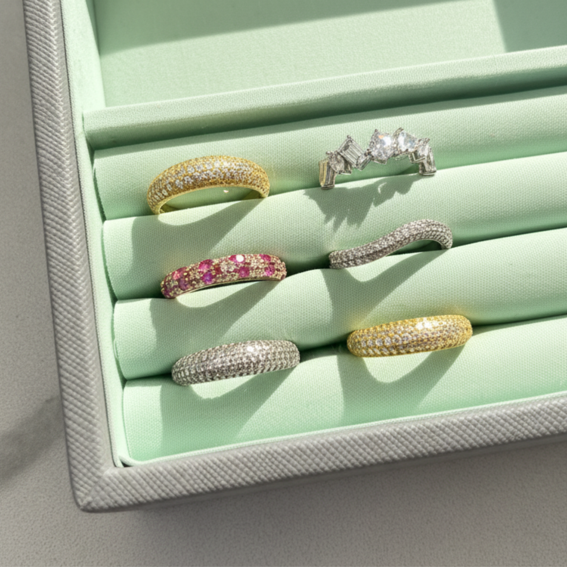 Set of rings displayed in a light green jewelry box
